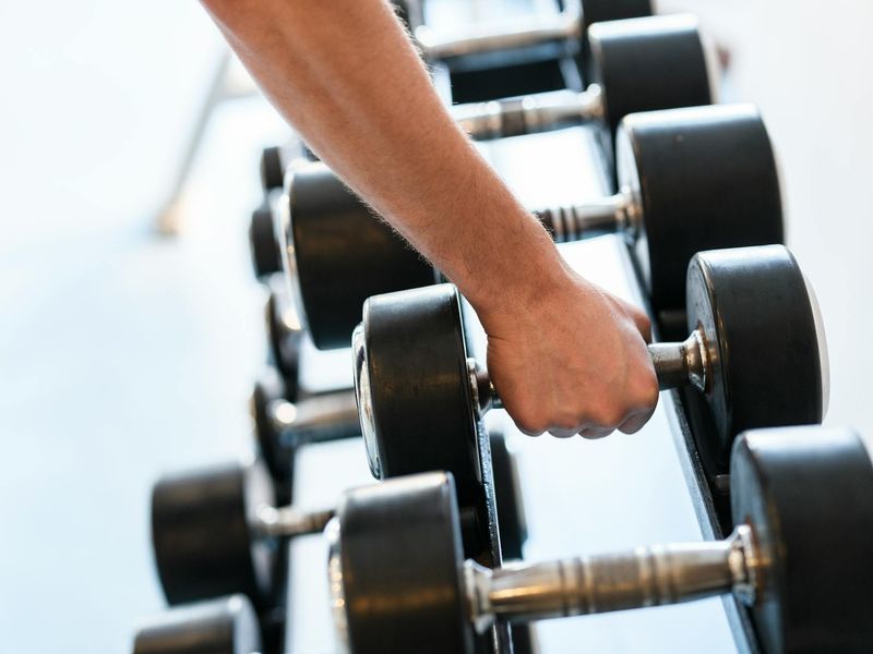 Close-up of a man's hands gripping a dumbbell firmly.