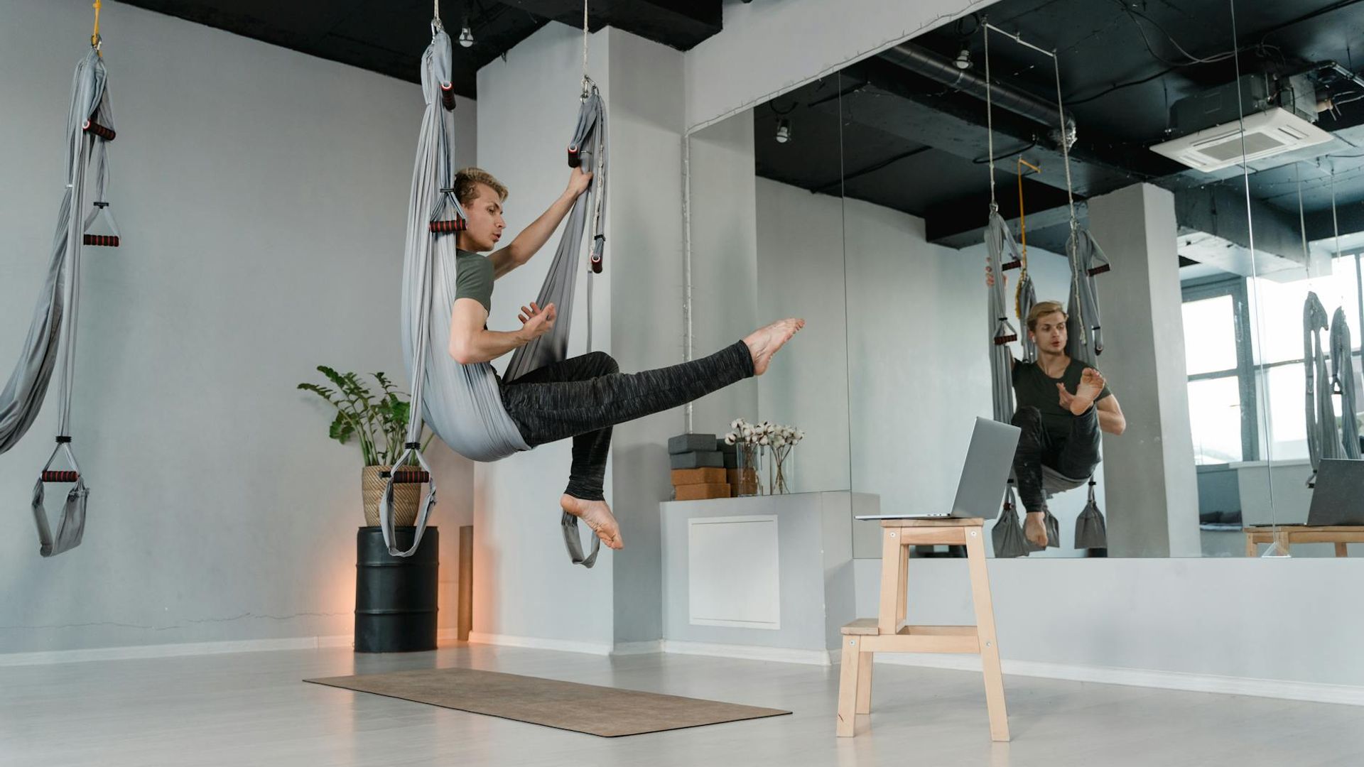 Man doing focused strength exercises in a minimalist studio environment.