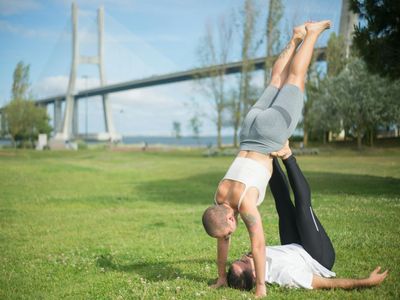Man standing in a balance yoga pose in silhouette.