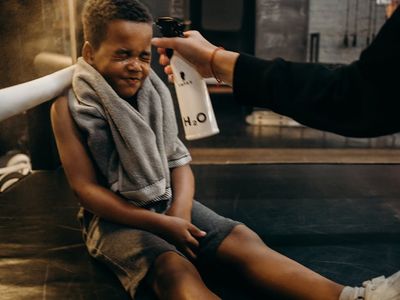 Water bottle and towel on a bench near training equipment.